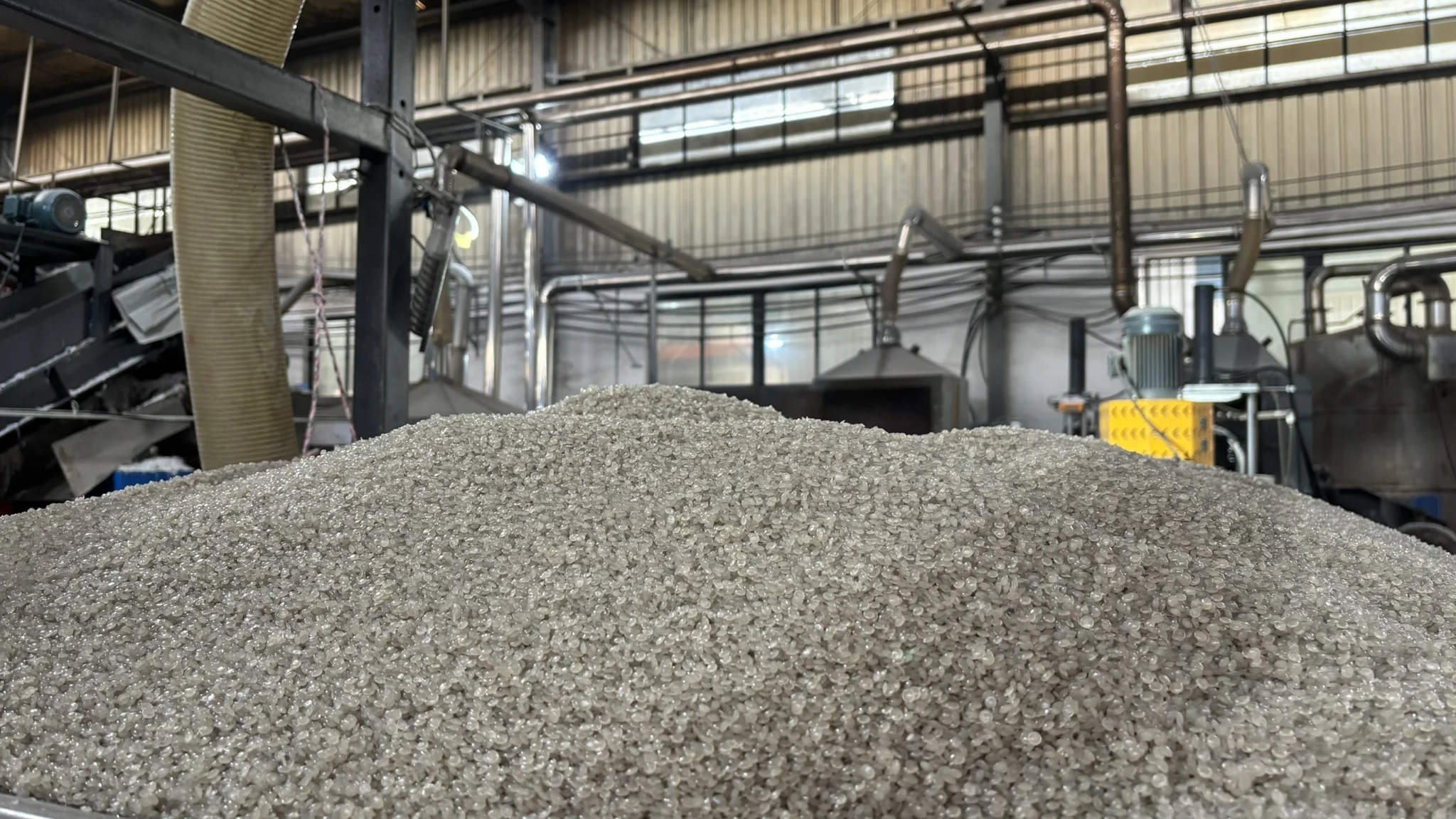 Recycled pellets pictured with production equipment at Hung Shing